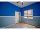 Bright bedroom featuring a neutral wainscot, blue walls, closet and window at 26633 N 41St Way, Cave Creek, AZ 85331