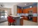 Stylish kitchen with wood cabinetry, stainless appliances, a breakfast bar, and access to backyard at 26633 N 41St Way, Cave Creek, AZ 85331
