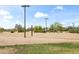 Outdoor sand volleyball court with net, surrounded by grass and desert landscaping under a bright sky at 26633 N 41St Way, Cave Creek, AZ 85331