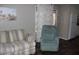 Cozy living room showcasing a striped sofa and a comfortable green recliner at 303 S Recker Rd # 247, Mesa, AZ 85206