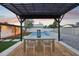 Backyard patio area featuring a pergola with a table and chairs beside a swimming pool and artificial grass at 3043 E Hartford Ave, Phoenix, AZ 85032