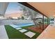 A backyard featuring a sparkling pool, turf grass, and a patio area, perfect for relaxation at 3043 E Hartford Ave, Phoenix, AZ 85032
