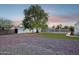Spacious backyard with gravel, a mature tree, artificial turf, and play equipment, offering ample space for outdoor activities at 3043 E Hartford Ave, Phoenix, AZ 85032