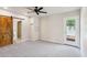 Open concept bedroom with carpet flooring, barn door to bathroom, and backyard access at 3043 E Hartford Ave, Phoenix, AZ 85032