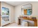 Bright entryway featuring a wood console table, stylish mirror, and a view of the outdoors through a glass door at 3043 E Hartford Ave, Phoenix, AZ 85032