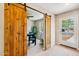 Home office with barn door entrance, featuring a large desk and stylish decor at 3043 E Hartford Ave, Phoenix, AZ 85032