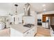 Open-concept kitchen with island, stainless steel range hood, and modern pendant lighting at 3043 E Hartford Ave, Phoenix, AZ 85032