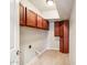Bright laundry room with ceramic tile floor and wooden cabinets at 3043 E Hartford Ave, Phoenix, AZ 85032