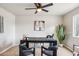 Bright office with a dark desk, stylish chairs, decorative art, and a ceiling fan at 3043 E Hartford Ave, Phoenix, AZ 85032
