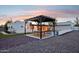 A cozy backyard patio with a wooden pergola, dining table, and view of the pool at twilight at 3043 E Hartford Ave, Phoenix, AZ 85032