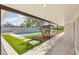 Spacious patio area with tile flooring, artificial grass, and walkway leading to a pool and backyard at 3043 E Hartford Ave, Phoenix, AZ 85032