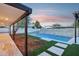 Inviting backyard pool with travertine pavers, wood pergola, green turf, and wood chip landscaping at 3043 E Hartford Ave, Phoenix, AZ 85032