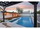Sparkling pool surrounded by stylish patio, turf grass, and a covered patio area, perfect for relaxation at 3043 E Hartford Ave, Phoenix, AZ 85032