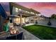 A backyard features an outdoor dining set, a fire pit, patio furniture, and a green lawn at 306 W Culver St, Phoenix, AZ 85003