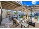 This backyard has a dining set, patio furniture, a pergola, lush grass, and beautiful landscaping at 306 W Culver St, Phoenix, AZ 85003