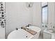 Elegant bathroom with a freestanding tub, dark faucet, and white tiled walls at 306 W Culver St, Phoenix, AZ 85003