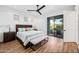 Sunlit bedroom features wood floors, ceiling fan, and a sliding glass door to a private balcony at 306 W Culver St, Phoenix, AZ 85003