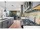 Contemporary kitchen flows to the outdoor space, featuring gray cabinets, quartz countertops, and a gas range at 306 W Culver St, Phoenix, AZ 85003