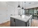 Bright kitchen features an island with white countertop, dark cabinets, and modern pendant lighting at 306 W Culver St, Phoenix, AZ 85003