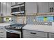 Modern kitchen with gray cabinetry, stainless steel appliances, and a stylish black and white backsplash for a contemporary design at 306 W Culver St, Phoenix, AZ 85003