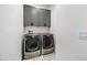Modern laundry room with gray cabinets and front load washer and dryer on a patterned tile floor at 306 W Culver St, Phoenix, AZ 85003