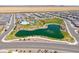 Aerial view of the community featuring a pool, park, playground, lake, and well-maintained landscaping at 35175 W Marin Ave, Maricopa, AZ 85138