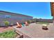 This backyard has mature trees, desert landscaping, a brick paved patio, and a small patch of grass at 35175 W Marin Ave, Maricopa, AZ 85138