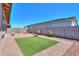 This backyard has a brick paved patio, small section of grass, and mature desert landscaping at 35175 W Marin Ave, Maricopa, AZ 85138
