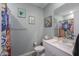 Clean bathroom with a floral shower curtain, framed art, and a vanity with a sink at 35175 W Marin Ave, Maricopa, AZ 85138