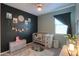 Cozy Bedroom featuring a crib, dark accent wall, and stylish decor at 35175 W Marin Ave, Maricopa, AZ 85138