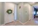 Bright entryway with a white door adorned with a wreath, tile flooring, and neutral wall paint at 35175 W Marin Ave, Maricopa, AZ 85138
