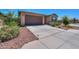 Home featuring a concrete driveway leading to a two-car garage, complemented by desert landscaping at 35175 W Marin Ave, Maricopa, AZ 85138