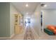 Hallway decorated with display cabinet, neutral walls, and tiled flooring leading to other rooms at 35175 W Marin Ave, Maricopa, AZ 85138