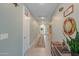 Inviting hallway with neutral tones, tile flooring, and stylish decor leading to a bright front door at 35175 W Marin Ave, Maricopa, AZ 85138
