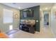 Modern living room with large television, decorative wall art, and built-in fish tanks with storage at 35175 W Marin Ave, Maricopa, AZ 85138