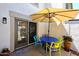 Charming patio featuring a vibrant blue table and seating set with a retractable umbrella for shade at 4114 E Union Hills Dr # 1088, Phoenix, AZ 85050