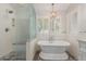 Stunning bathroom with a freestanding tub, glass shower, and chandelier at 4335 E Enrose St, Mesa, AZ 85205