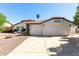 Charming home featuring a well-maintained lawn, two-car garage, and a warm, inviting facade at 4335 E Enrose St, Mesa, AZ 85205