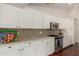 Updated kitchen boasts white cabinetry, a mosaic backsplash, and stainless steel appliances at 4335 E Enrose St, Mesa, AZ 85205
