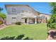 Expansive backyard featuring lush green lawn, patio, and covered seating area at 6027 N 132Nd Dr, Litchfield Park, AZ 85340