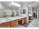 Luxurious bathroom featuring dual sinks, generous mirror, and walk-in shower at 6027 N 132Nd Dr, Litchfield Park, AZ 85340