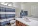 Functional bathroom with a single sink vanity, toilet, and shower with a striped curtain at 6027 N 132Nd Dr, Litchfield Park, AZ 85340