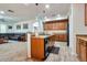 Modern kitchen with wood cabinetry, stainless appliances, and open layout to the living area at 6027 N 132Nd Dr, Litchfield Park, AZ 85340