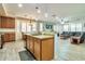 Well-lit kitchen featuring an island with a sink and a view into the living room at 6027 N 132Nd Dr, Litchfield Park, AZ 85340