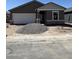 New home under construction with a neutral color palette, stone accents, and an attached two-car garage at 6057 E Artemis Dr, Florence, AZ 85132