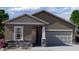 Charming single-story home with a neutral palette, stone accents, and an attached two-car garage at 6057 E Artemis Dr, Florence, AZ 85132