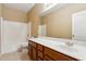 Well-lit bathroom featuring a vanity with a large mirror, a bathtub with white tile, and neutral wall colors at 6103 S 54Th Ave, Laveen, AZ 85339