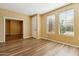 Spacious living room with wood floors, light-colored walls, and natural light streaming through the windows at 6103 S 54Th Ave, Laveen, AZ 85339