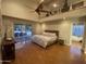 Spacious main bedroom with hardwood floors, a ceiling fan, and large sliding doors to the outside at 6408 E Gary Rd, Scottsdale, AZ 85254