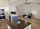 Spacious living room and kitchen area featuring vaulted ceilings, modern lighting, and wood flooring at 6873 S Lake Forest Ct, Chandler, AZ 85249